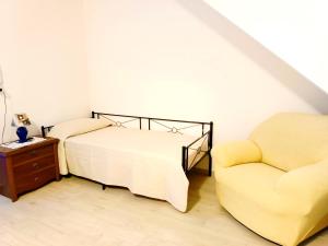 a bedroom with a bed and a chair at Casa Palmieri bilocale Indipendente con Giardino Privato Relax sul Monte Amiata in Castel del Piano