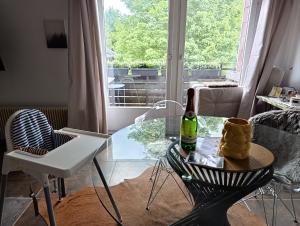 a living room with a glass table and a bottle of wine at Manjana`s Waldblick in Braunlage