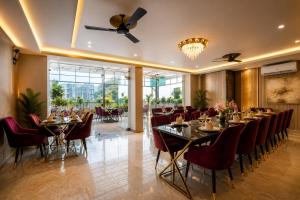 a dining room with tables and chairs and a chandelier at Sunburry Hotel Tapovan Rishikesh in Narendranagar