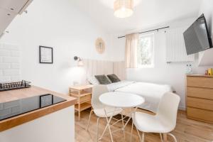 a white kitchen with a white table and white chairs at Enjoy! Piaseczno in Piaseczno
