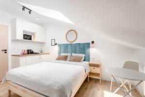 a white bedroom with a bed and a table at Enjoy! Piaseczno in Piaseczno +65 photos