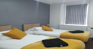 a room with two beds with yellow pillows on them at South Beach Kings Promenade Hotel in Blackpool