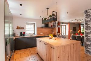 a kitchen with a wooden island in the middle at Une parenthèse en Ardenne in Nollevaux