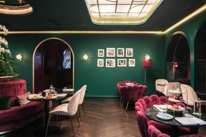 a restaurant with tables and chairs and green walls at Eurostars Josefine in Vienna