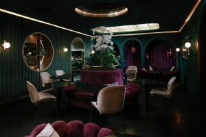 a room with purple chairs and a table with flowers at Eurostars Josefine in Vienna