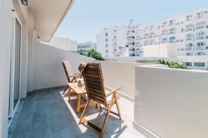 two chairs on a balcony with a view of a building at A&B Rooms Rodos Center in Rhodes Town