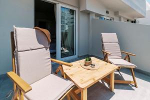 a patio with two chairs and a wooden table at A&B Rooms Rodos Center in Rhodes Town +25 photos