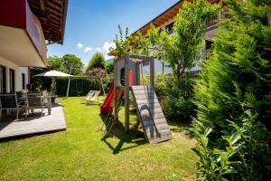 a backyard with a wooden deck and a play structure at Apart Denise in Fügen +96 photos