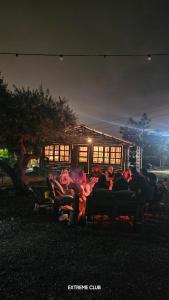a group of people sitting on chairs in front of a house at extreme park in Deir Ḥannā