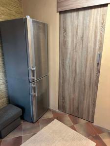 ein Edelstahlkühlschrank neben einer Schiebetür in der Unterkunft MiniApartament in Psary Małe