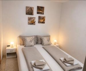 a bedroom with a large white bed with two lamps at apartmenttwelve in Trogir +5 photos