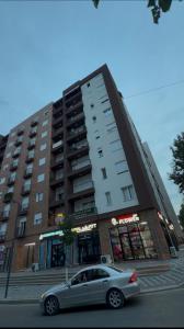 a car parked in front of a large building at Apartment 51 Luxury in Kamëz