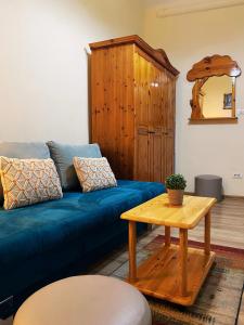 a living room with a blue couch and a table at The Stone Garden Apartment - free parking, private yard in Sinaia