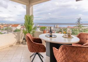 a balcony with a table and chairs and a view of the ocean at Sunny Day self check in in Rijeka