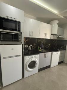 a kitchen with a microwave and a washing machine at appart plage in M'diq