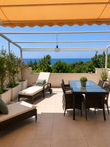 a patio with a blue table and chairs at Glory Guest House Sea View in Mandaradoni