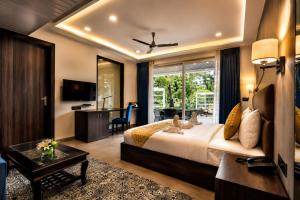a bedroom with a bed and a living room with a desk at Ramatan Resort in Vagator