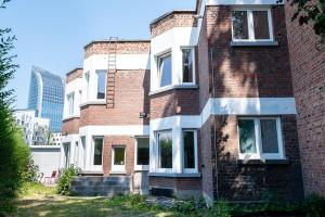 a brick building with white windows on the side of it at Cool Cool House in Liège