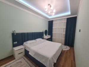 a bedroom with a white bed and a blue ceiling at Afsona in Namangan