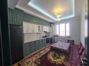 a kitchen with green cabinets and a table in it at Afsona in Namangan