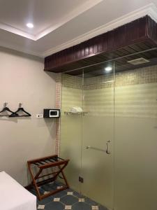 a shower with a glass door in a room at Margot Guest House in Sanur