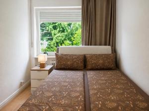 a bedroom with a bed and a large window at Moscow Areal Suite in Baden-Baden