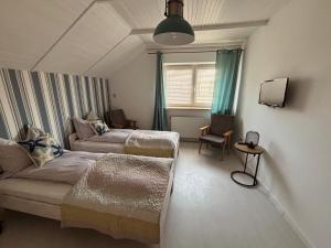 a room with two beds and a couch and a window at Pensjonat Dom Latarnika in Grzybowo