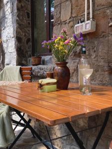 a wooden table with a bottle of wine and flowers at The Stone Garden Apartment - free parking, private yard in Sinaia