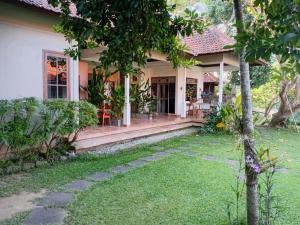 a house with a green lawn in front of it at Margot Guest House in Sanur