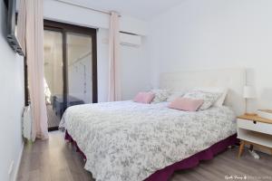 a white bedroom with a large bed with pink pillows at Festival de Cannes résidence de luxe piscine tennis in Vallauris +23 photos