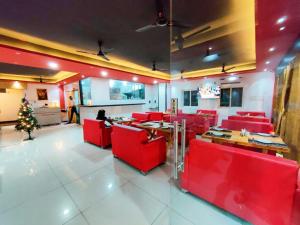 a restaurant with red chairs and a christmas tree at Hotel Hibiscus Tree- Bachupally in Hyderabad