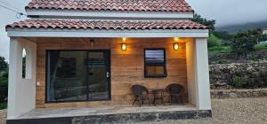 a small house with two chairs on a patio at Dara House Private Pension in Jangheung