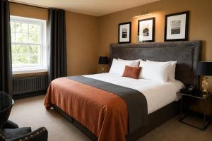 a bedroom with a large bed and a window at The Fenwick Hotel in Kilmarnock +68 photos
