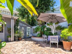 a patio with a table and chairs and an umbrella at Himmelblau Boutique Bed and Breakfast in Cape Town