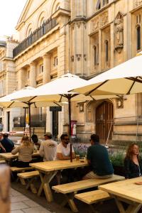 a group of people sitting at tables under umbrellas at Hort's Townhouse in Bristol