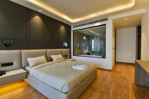 a bedroom with a large bed and a large window at Melange Hotel - Golf course road in Gurgaon