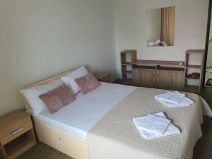 a bedroom with a bed with two towels on it at Casa Tim in Tulcea +32 photos
