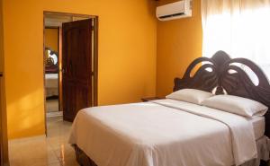 a bedroom with a large bed with yellow walls at Elegant Villa in Nagua with Private Pool and Jacuzzi in Nagua