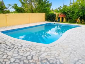a swimming pool with blue water in a backyard at Elegant Villa in Nagua with Private Pool and Jacuzzi in Nagua