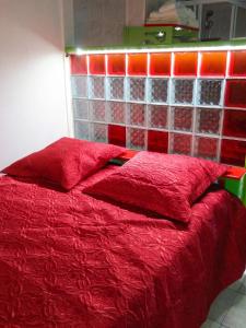 a red bed with red pillows in a bedroom at Studio charmant à Rivière Salée - 22 m² + Parking in Rivière-Salée