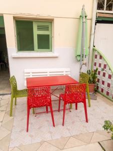 a red table and two chairs and an umbrella at Studio charmant à Rivière Salée - 22 m² + Parking in Rivière-Salée
