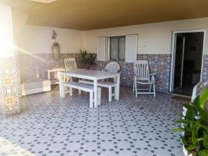 a patio with a table and chairs on a tile floor at Charming House in Requião with Shared Pool in Requião