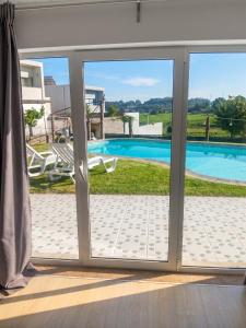 a sliding glass door with a view of a swimming pool at Charming House in Requião with Shared Pool in Requião