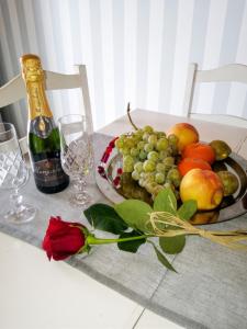 a table with a plate of fruit and a bottle of wine at Charming House in Requião with Shared Pool in Requião +8 photos