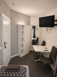 a room with a desk and a table with a chair at M&M Apartments in Augustdorf