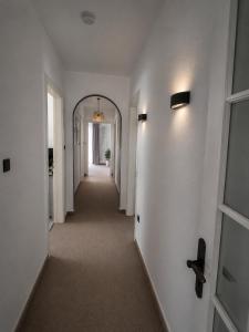 a hallway with an archway in a white room at M&M Apartments in Augustdorf