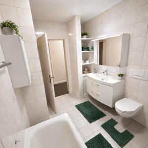 a white bathroom with a sink and a toilet at M&M Apartments in Augustdorf +10 photos