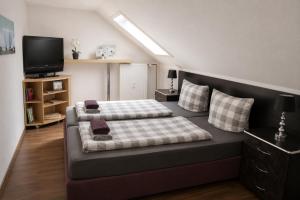 a bedroom with two beds and a flat screen tv at M&M Apartments in Augustdorf