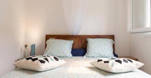a bedroom with a bed with two pillows on it at Villa ensoleillée aux Anses-d'Arlet avec piscine privée in Les Anses-dʼArlets