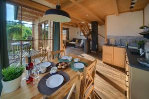 a kitchen and dining room with a wooden table with chairs at Domek Pod Wierchami z Jacuzzi in Kościelisko